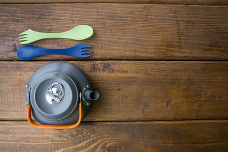 tourist gray kettle, fork and spoon stand on the tableの写真素材