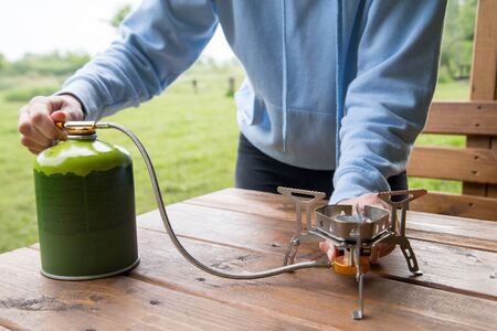 cooking in the campsite with a gas burner and gas cylinderの写真素材