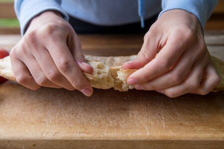 girl breaks pita bread with her hands on a picnic at the campsiteの写真素材