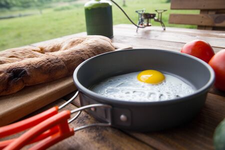 fried scrambled eggs in a pan on a picnic at the campsiteの写真素材
