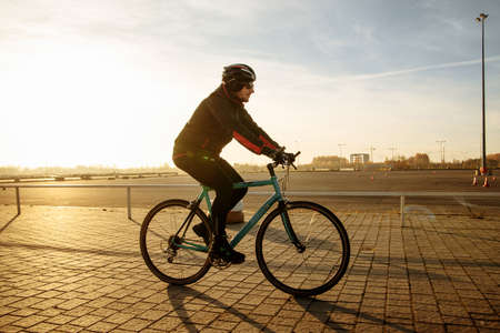 cyclist in black clothes and helmet trains on a bicycleの写真素材