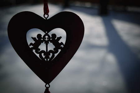 heart with two cupids in on the background of winter snowの写真素材