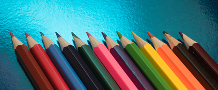 bright color pencils on blue glossy backgroundの写真素材