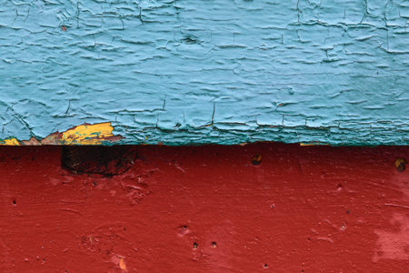 Contrasting background divided into two halves horizontally, the top one - wooden, painted blue and cracked, the bottom one - concrete, painted with red paintの写真素材