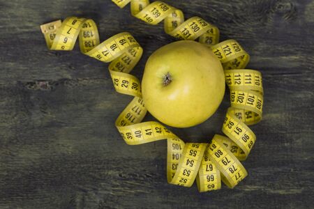 Apple wrapped in a yellow ribbonの写真素材