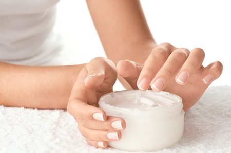 Woman applying cream isolated on white backgroundの写真素材