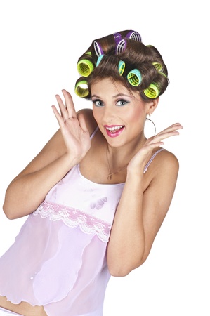 Portrait of young woman with hair-curlers - isolated on white background. Positive expression, hands near the face. の写真素材