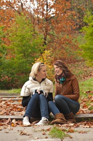 Young pretty girls laughing at the autumn parkの写真素材