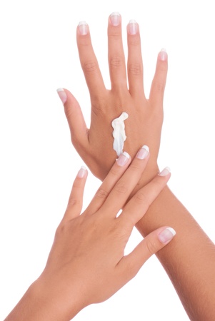 Closeup of beautiful female hands applying hand cream isolated on white backgroundの写真素材