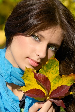 Portrait of a beautiful girl with golden and red autumn leavesの写真素材