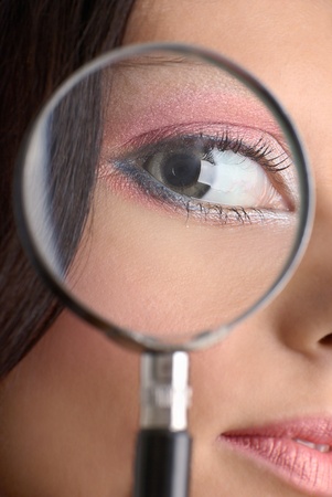 Girl looking through the magnifying glassの写真素材