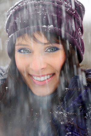 Portrait of a beautiful girl in snowfall.の写真素材