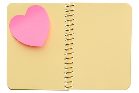 Open spiral notebook with post-it note in shape of heart isolated on white backgroundの写真素材