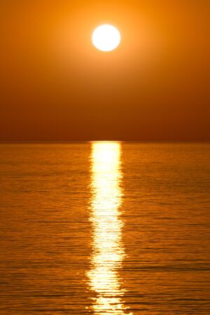 Beautiful golden sunrise over the waterの写真素材