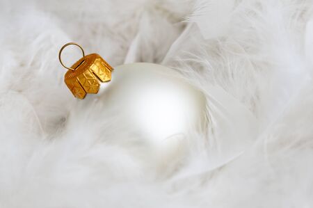 One white christmas bulb on white fluffy feathersの写真素材