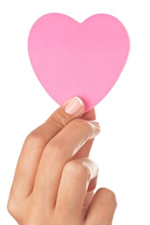 Woman hand holding a pink heart shape post-it isolated on white の写真素材
