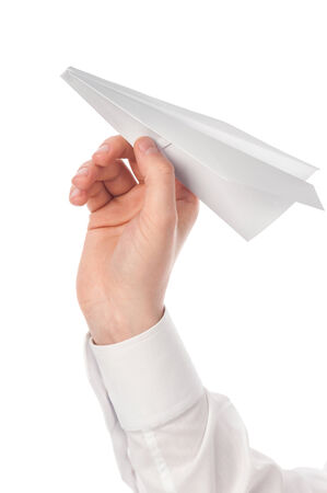 Man's hand launching white paper airplane isolated on white background.の写真素材