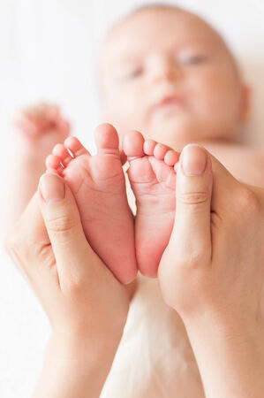 Baby feet in mommy's handsの写真素材