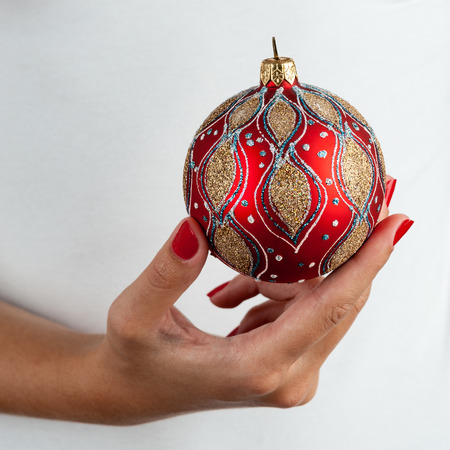 Woman holding christmas red ball, close-up of hands on white t-shirt background.の写真素材