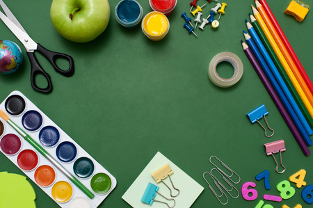 School supplies on blackboard background. Empty space in the middle of green blackboard. Education concept の写真素材
