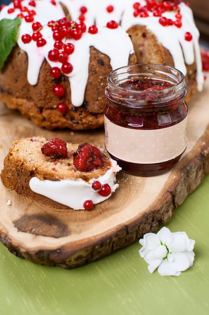 Cranberry cake with jam jar on wooden board. Shallow DOF.の写真素材