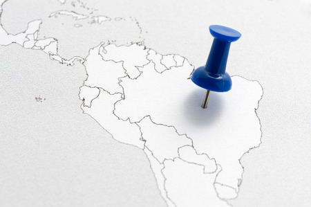Close-up of a contour map of South America with a blue pin on Brazil.の写真素材