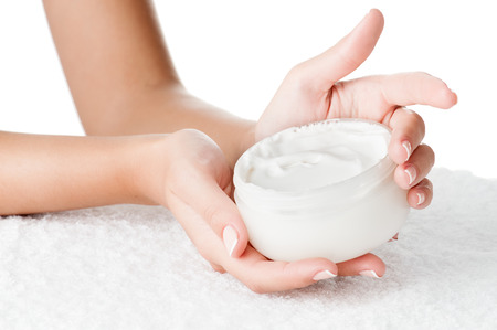 Woman applying cream isolated on white backgroundの写真素材