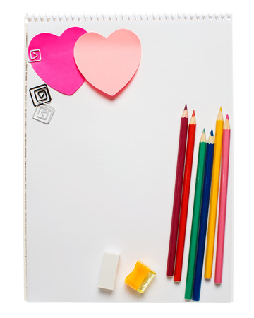 White notepad with two heart shape sticky notes, pencils, rubber and pencil sharpener isolated on whiteの写真素材