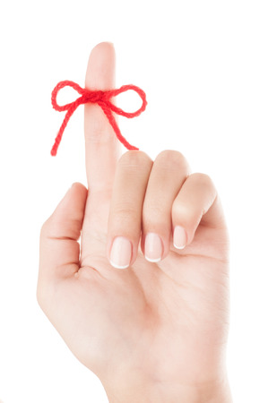 Red bow on finger isolated on white background.の写真素材