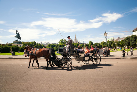 Vienna, Austria - August 11, 2011: Horse carriage with tourists and bronze statue Erzherzog Karl Archduke Charles on background in Heldenplatz, Vienna on 11th of August 2011. Since the 17th century, the horse-drawn carriages characterize Viennas cityscapeのeditorial素材