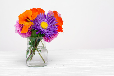 Colorful autumn flowers in the glass over white. Shallow focus. Horizontal composition.の写真素材