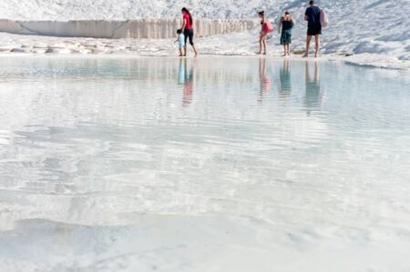 Travertine water surface with unrecognizable people on background, Pamukkale, Denizli, Turkey.の写真素材