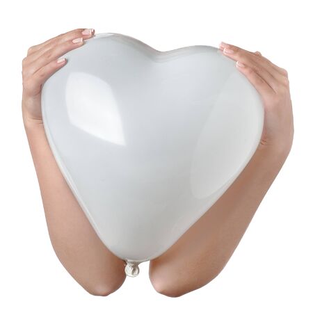 Woman hands holding a white balloon in the shape of a heart isolated over white, close-up composition.の写真素材