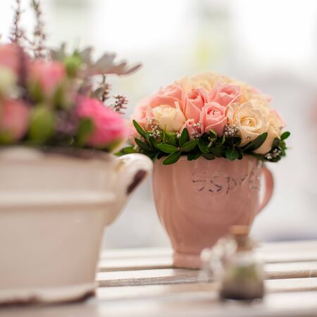 Flower arrangement of multi-colored roses in the cup. Wedding ceremony. Floristic design close-up. Shallow DOF, selective focus, square composition.の写真素材