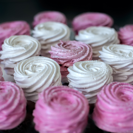 Pink and white marshmallows (meringue,zephyr), soft selective focus background. Square composition.の写真素材