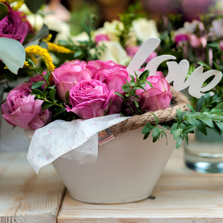 Flower arrangement of pink roses on counter desk in flower shop, floristic art close-up. Decor or beautiful gift for lovely woman as valentine's day present. Square composition.の写真素材