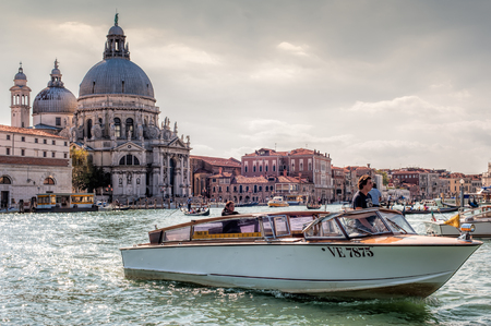 VENICE, ITALY - SEPTEMBER 21, 2012: Water taxi is sailing along the Grand Canal with Santa Maria della Salute church in background on 21 September 2012 in Venice, Italy. のeditorial素材
