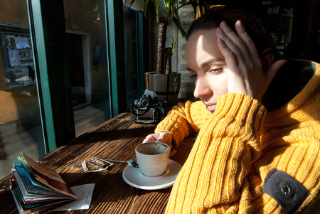Tired tourist woman with a cup of coffee in the cafeの写真素材