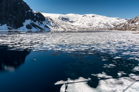 The frozen lake on route 63 Geiranger-Stryn, Norway. With norwegian mountains in the background. Cold landscape background.の写真素材