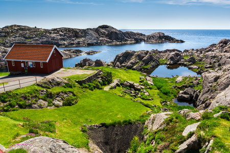 Landscape with red house near Lindesnes, Norway. The coast of southern Norway with an ocean view, rocky sea coast, South Norway, Lindesnes Fyr beacon.のeditorial素材