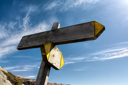 Arrow of wood on blue sky background. Signpost concept.の写真素材