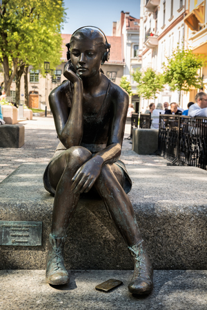 OSLO, NORWAY - MAY 30, 2018: Bronze sculpture at Bankplassen is called Seated girl with headphones and is made by Marit Krogh in 2014, Oslo, Norwayのeditorial素材