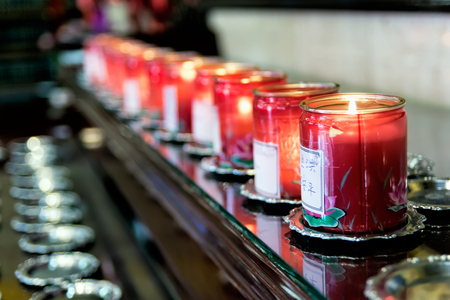 Interior of Fo Guang Shan He Hua buddhist temple in Zeedijk, Amsterdam, the Netherlands. Line of burning candles, prayer offering to Buddha.の写真素材