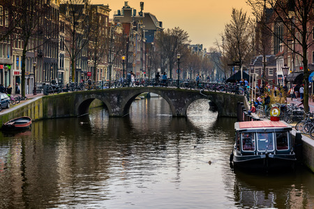 AMSTERDAM, NETHERLANDS - APRIL 10, 2018: Amsterdam canal with typical dutch houses and boats in the evening, Amsterdam, Netherlands.のeditorial素材