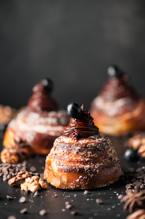 Sweet buns with chocolate cream, spices and berries on the dark background. Selective focus, shallow DOF. Photo taken on workshop.の写真素材