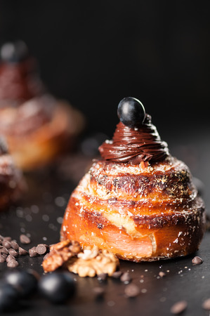 Sweet buns with chocolate cream, spices and berries on the dark background. Selective focus, shallow DOF. Photo taken on workshop.の写真素材