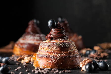 Sweet buns with chocolate cream, spices and berries on the dark background. Selective focus, shallow DOF. Photo taken on workshop.の写真素材