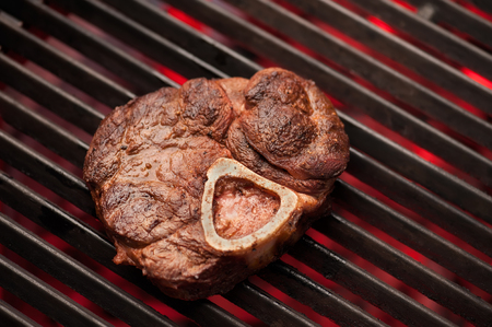 Grilling steak on the flaming grill, close-up, selective focus, horizontal shot. Photo taken on workshop.の写真素材