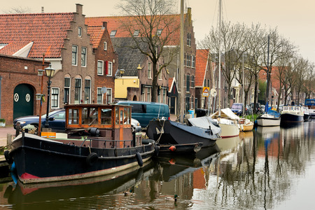 EDAM, NETHERLANDS - APRIL 14, 2018: Houses and boats on the canal in a small city Edam in Netherlands. Edam is a small village in the district Nordholland, Netherlands.のeditorial素材