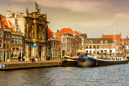 HARLEM, NETHERLANDS - APRIL 14, 2018: Spaarne river with boats and houses at sunset in Haarlem, Netherlands.のeditorial素材